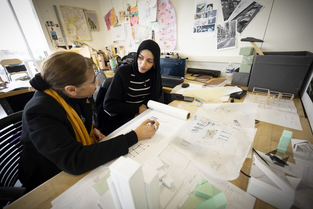 a student collaborates with their professor in class.