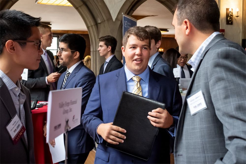 A Fox student converses with representatives of a local company.